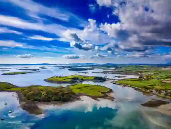 Luftaufnahme von Strangford Lough mit grünen Inseln und Booten unter einem weiten Himmel.
