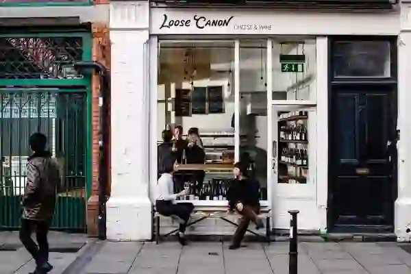 Außenansicht des Loose Canon, einem Käse- und Weinladen in Dublin, mit Menschen, die sich davor unterhalten.
