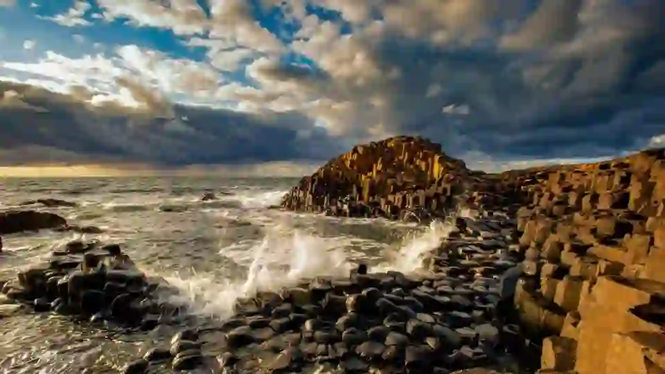 Wellen brechen über Basaltsäulen am Giant's Causeway in der Grafschaft Antrim.