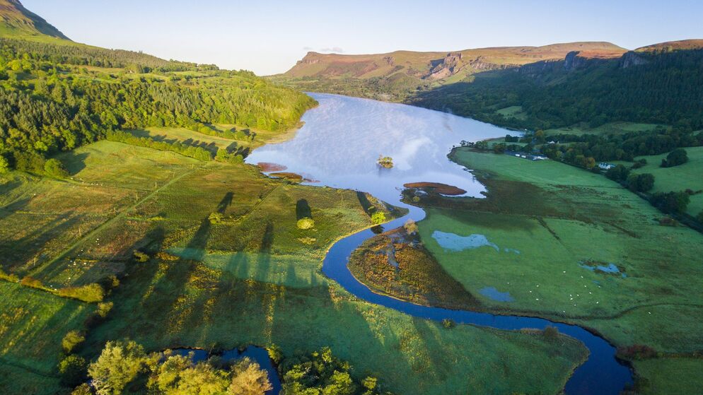 Aerial view of Bundoran countryside with river winding into lake surrounded by green fields and woodland.