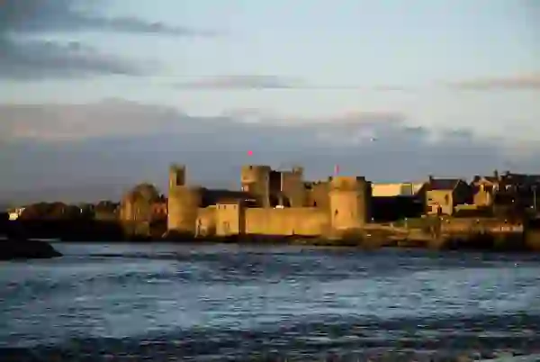 Vista del castillo del rey Juan al otro lado del río Shannon, en la ciudad de Limerick, al atardecer.
