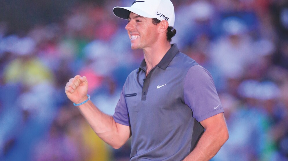 Golfer Rory McIlroy smiling and celebrating during a tournament.
