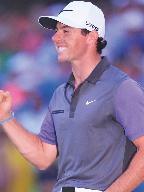 Golfprofessional Rory McIlroy lacht en viert tijdens een toernooi.