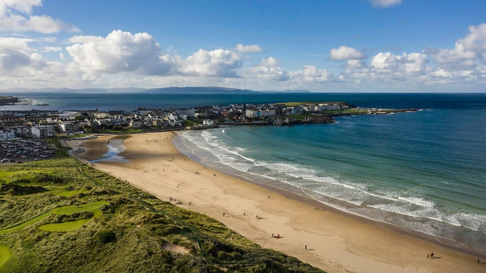 Seaside town and golf course at Royal Portrush featured in promotion for The 153rd Open in 2025.