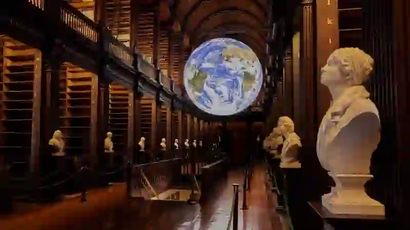 The Long Room library at Trinity College Dublin with marble busts and a suspended Earth globe installation.