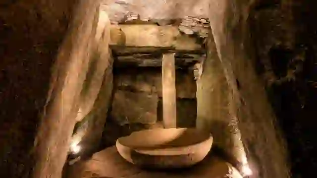 Inside Newgrange passage tomb chamber, County Meath, with stone basin and carved walls.