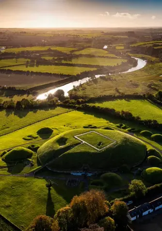 Aerial view of Knowth passage tomb and surrounding farmland beside the River Boyne, County Meath.