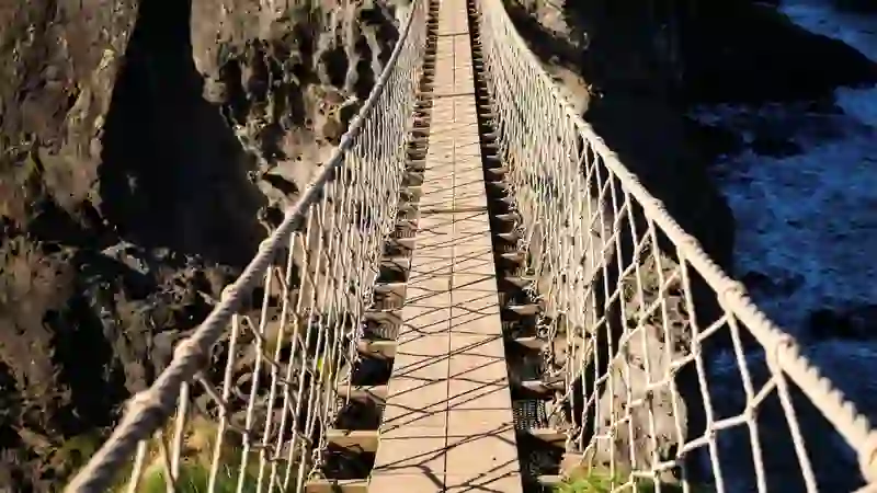 Carrick-a-Rede rope bridge stretching across a rocky chasm above the Atlantic Ocean in County Antrim.
