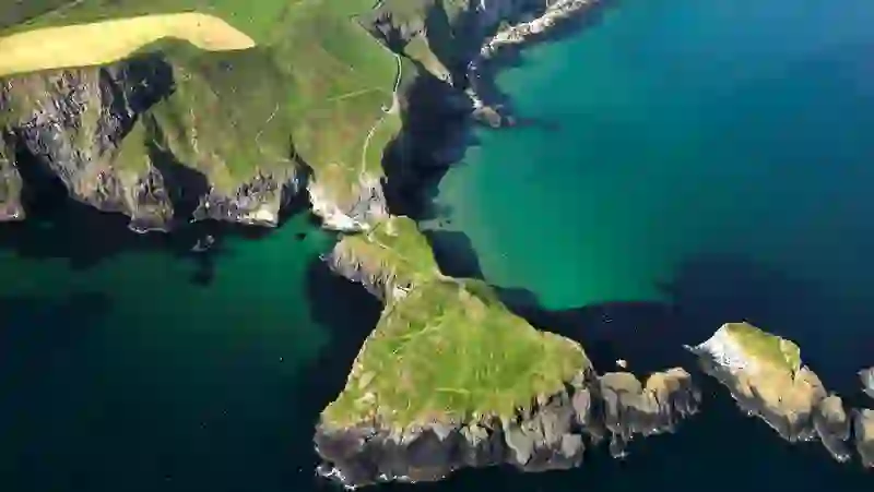 Aerial view of Carrick-a-Rede island and rope bridge surrounded by turquoise waters on the Causeway Coast.