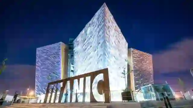 Nachtsicht auf das beleuchtete, winkelförmige Gebäude von Titanic Belfast im Titanic Quarter, Belfast.