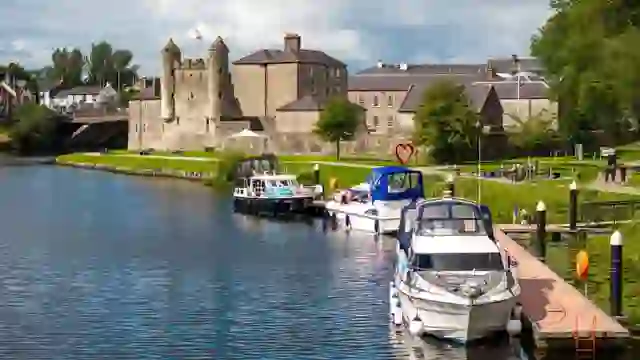 Boote, die am Fluss Erne vor Anker liegen, mit dem Schloss Enniskillen im Hintergrund, Grafschaft Fermanagh.