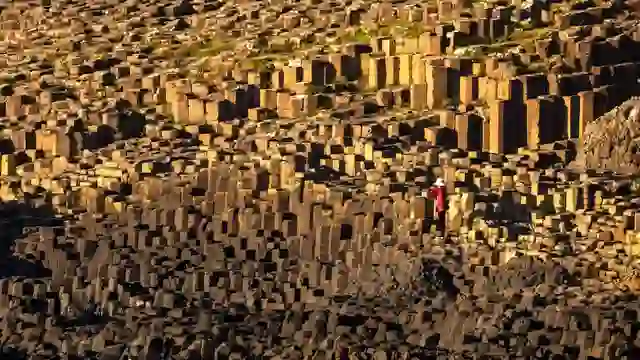 Visitor standing among the basalt columns of the Giant's Causeway on the Causeway Coast, County Antrim.