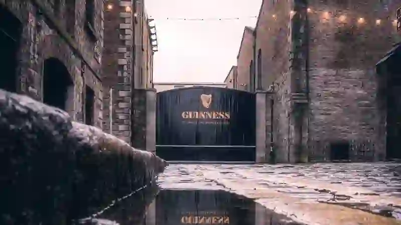 Das Tor des Guinness Storehouse in der St. James's Gate Brewery in Dublin, mit nassen Kopfsteinpflaster nach dem Regen.