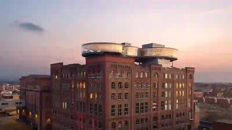 Die Fassade des Guinness Storehouse in Dublin bei Sonnenuntergang, mit der gläsernen Gravity Bar auf dem Dach.