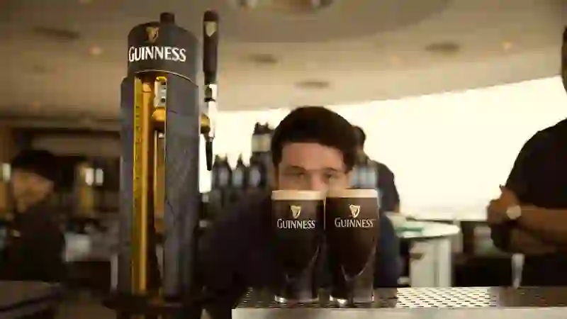 Barkeeper im Guinness Storehouse in Dublin servieren frisch gezapfte Guinness-Pints in der Gravity Bar.