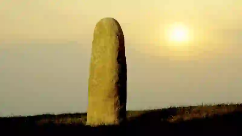 Lia Fáil, the Stone of Destiny, standing on the Hill of Tara in County Meath at sunset.