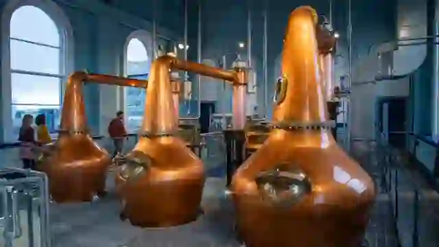 Kupferfarbene Whiskeys in den Titanic Distillers am Thompson Dock in Belfast. Hier entdecken Besucher die faszinierende Destillerie-Ausrüstung hautnah.