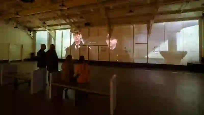 Besucher sehen einen Film, der in der Drill Hall der HMS Caroline in Belfast projiziert wird.