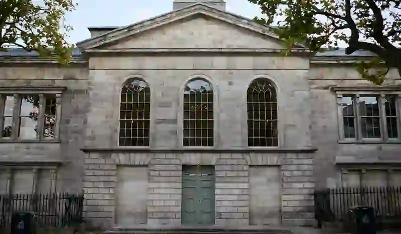 Exterior of Kilmainham Gaol Museum, Dublin, with neoclassical stone façade and arched windows.