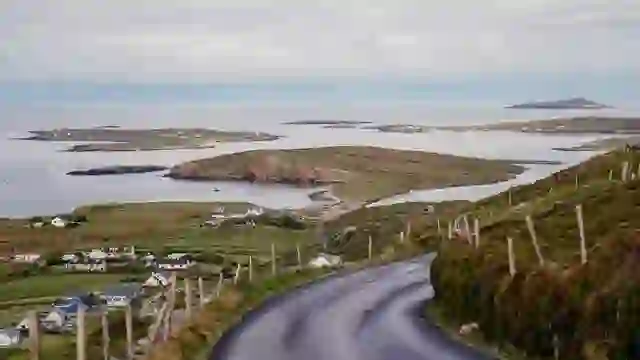 Strada costiera tortuosa con vista su isole e terre agricole a Connemara, nella contea di Galway.