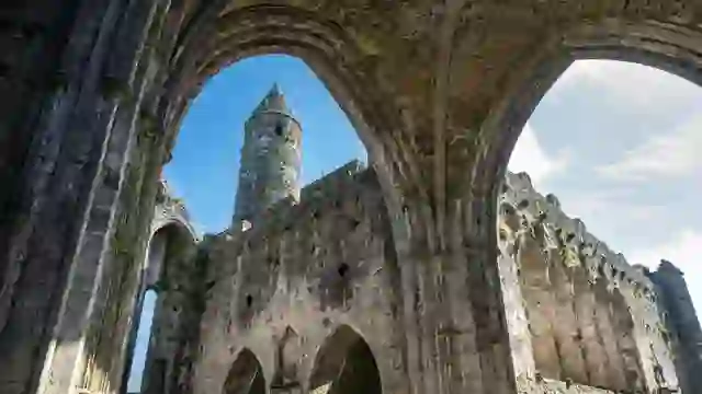 Stone arches framing the round tower and medieval ruins at the Rock of Cashel, County Tipperary.