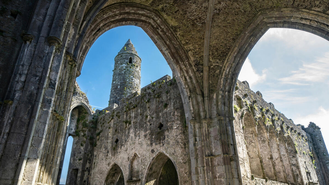 Stone arches framing the round tower and medieval ruins at the Rock of Cashel, County Tipperary.