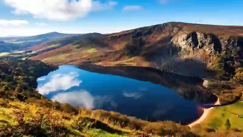Lough Tay, The Guinness Lake, Co Wicklow. Dark lake with sandy shore beneath cliffs in Wicklow Mountains.