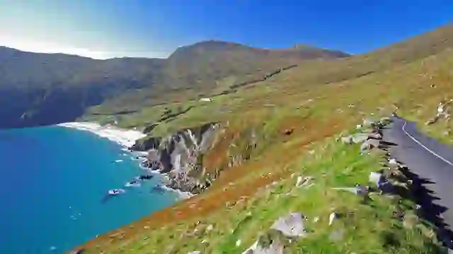 Carretera costera que serpentea junto a los acantilados cerca de Croagh Patrick, sobre las brillantes aguas azules del Atlántico.