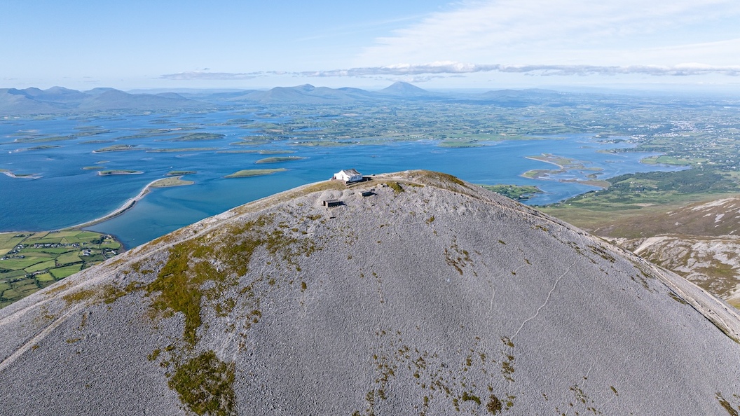 Capilla en la cima de Croagh Patrick con vistas a la bahía de Clew y al ondulado paisaje de Mayo.