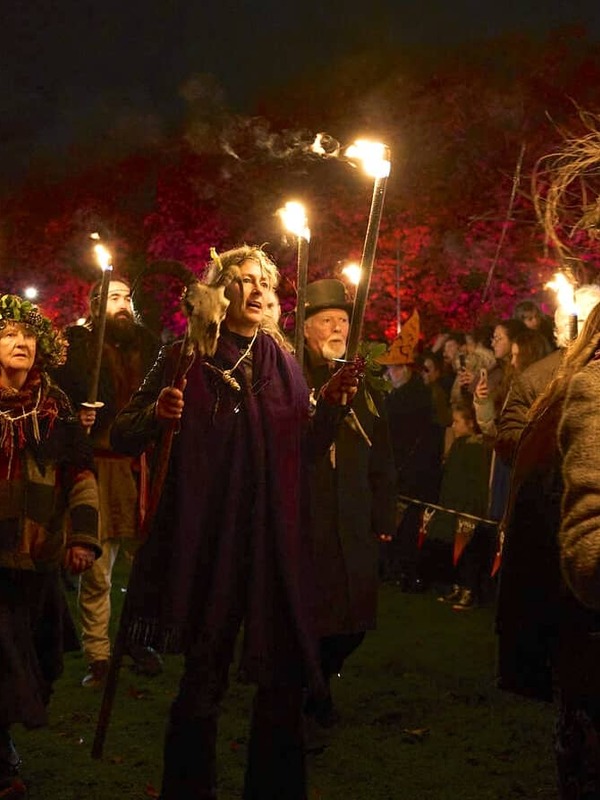 Crowds watch performers carrying flaming torches during the Púca Festival night parade in Ireland.
