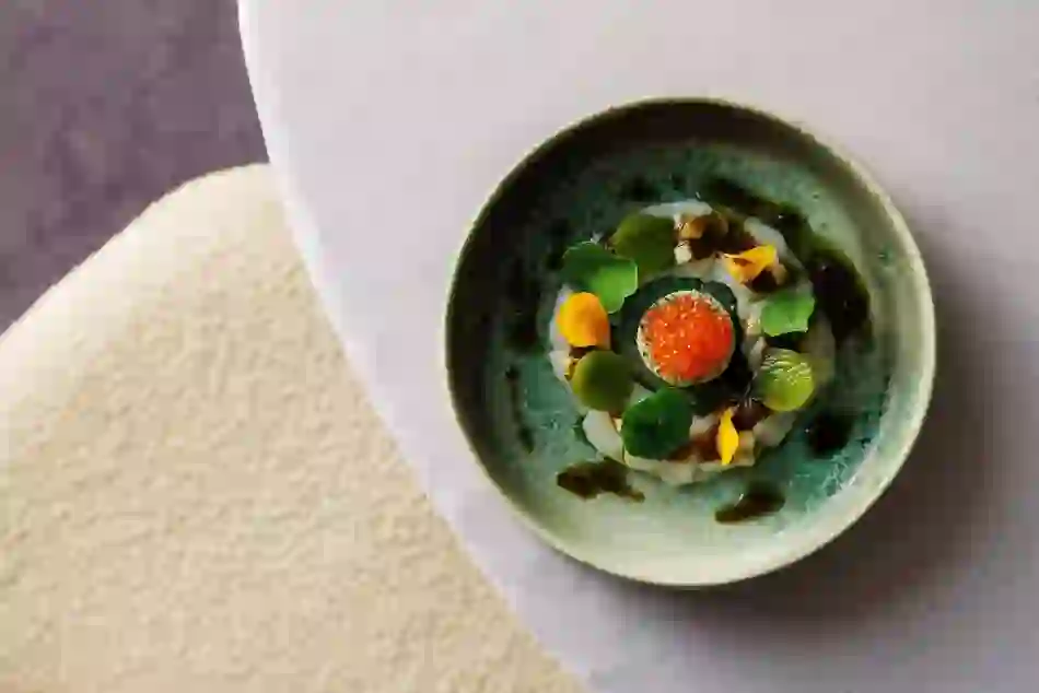 Gourmet seafood dish with herbs, edible flowers and roe served in an artisan ceramic bowl at Gregan's Castle, County Clare.
