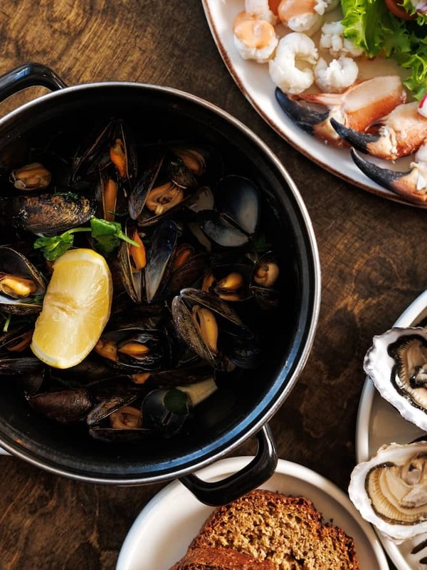Iers voedsel zoals vers zeevruchtengerecht bij Monk's, county Clare, met oesters, mosselen, krab en bruin brood geserveerd op een rustieke tafel.