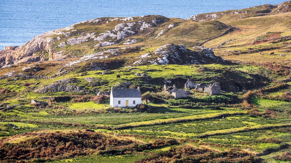 Traditional cottage and rugged coastal landscape on the Wild Atlantic Way in County Donegal.