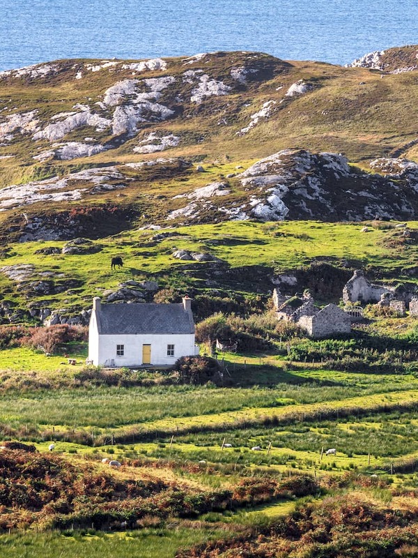 Traditional cottage and rugged coastal landscape on the Wild Atlantic Way in County Donegal.