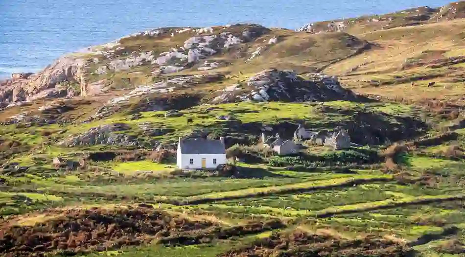 Traditional cottage and rugged coastal landscape on the Wild Atlantic Way in County Donegal.