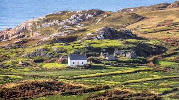 Traditional cottage and rugged coastal landscape on the Wild Atlantic Way in County Donegal.