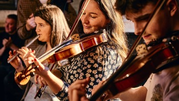 Traditional Irish musicians perform a lively session in a cosy pub in Belfast.