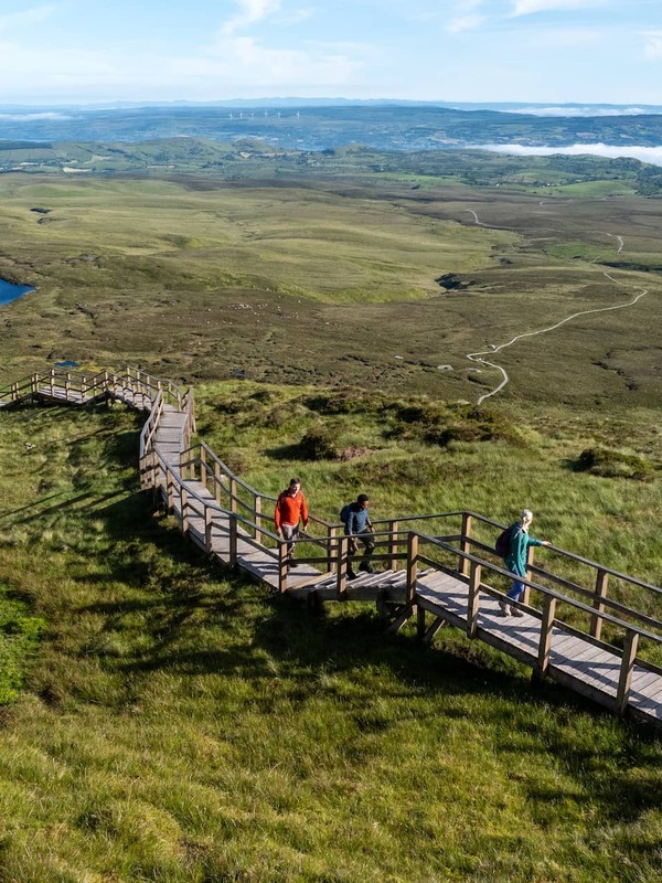 Walkers explore the Cuilcagh Boardwalk Trail amid sweeping upland scenery in County Fermanagh.