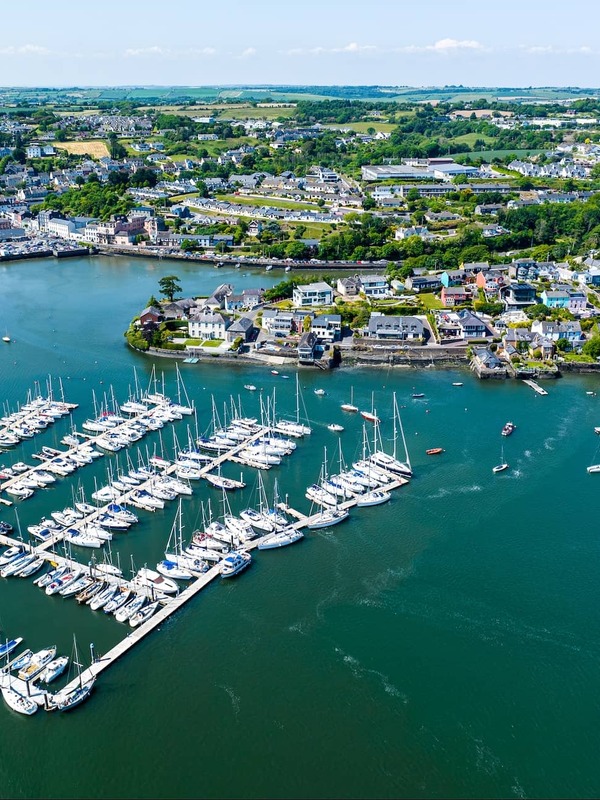Aerial view of Kinsale Harbour and marina in County Cork, with yachts and colourful waterfront buildings.