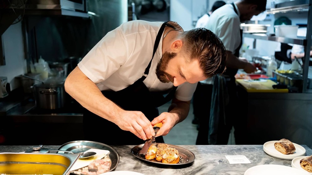 Chef preparing a signature dish at Variety Jones restaurant in Dublin, known for innovative contemporary dining.
