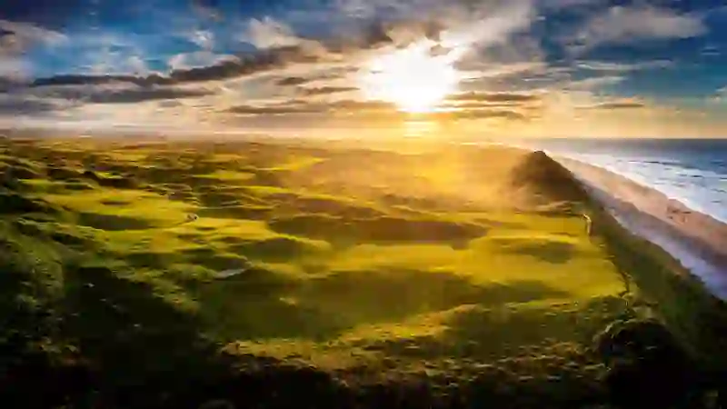 Le Royal Portrush Golf Club dans le comté d'Antrim avec des parcours côtiers et le phare sur la côte atlantique.