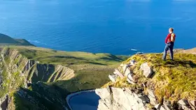 Walker overlooking the cliffs at Saddle Head on Achill Island, County Mayo.