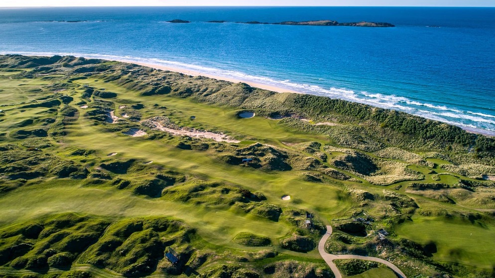 Aerial view of Royal Portrush Golf Club with rolling links fairways overlooking the Atlantic Ocean.