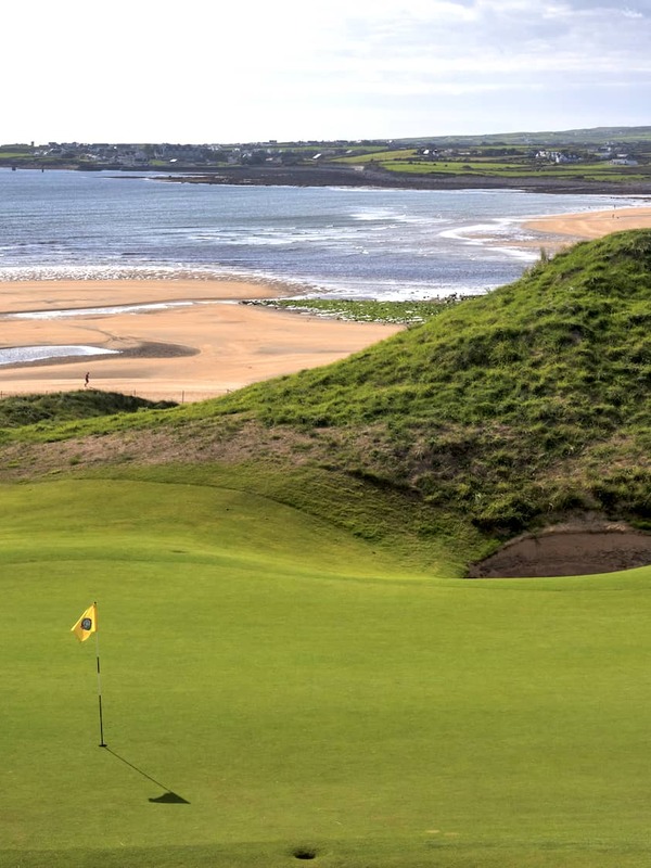 Green entouré de hautes dunes de sable au Lahinch Golf Club dans le comté de Clare.