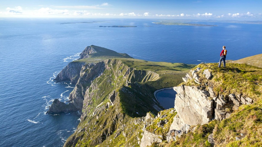 Walker overlooking the cliffs at Saddle Head on Achill Island, County Mayo.