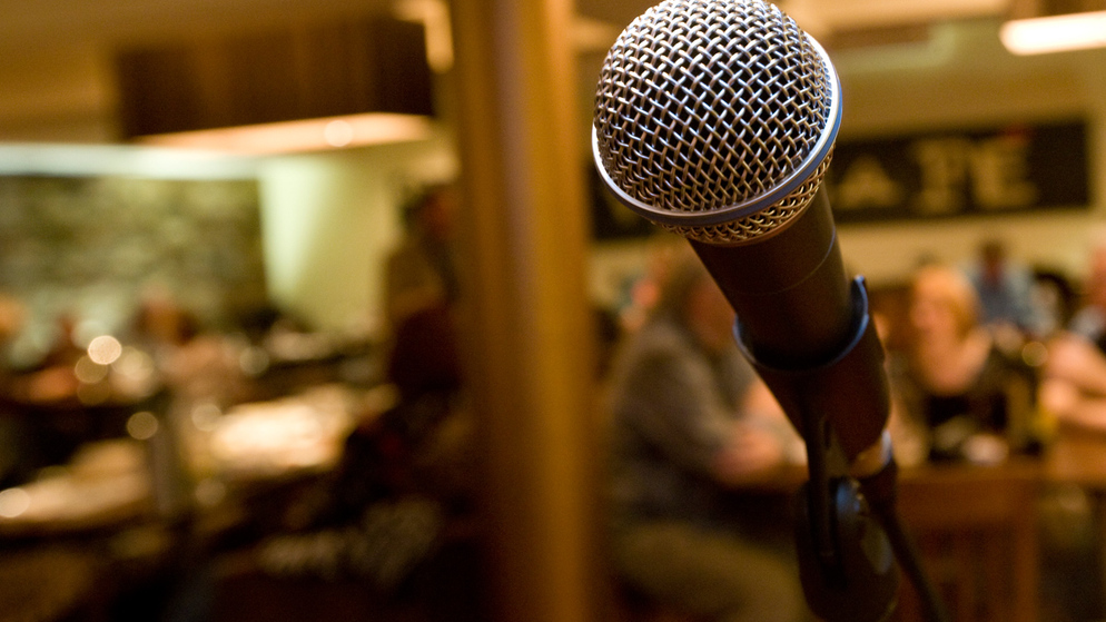 Eine Menschenmenge beim Lesen auf den Stufen vor einem mittelalterlichen Steingebäude während einer sonnigen Veranstaltung bei einem irischen Literatur-Festival.