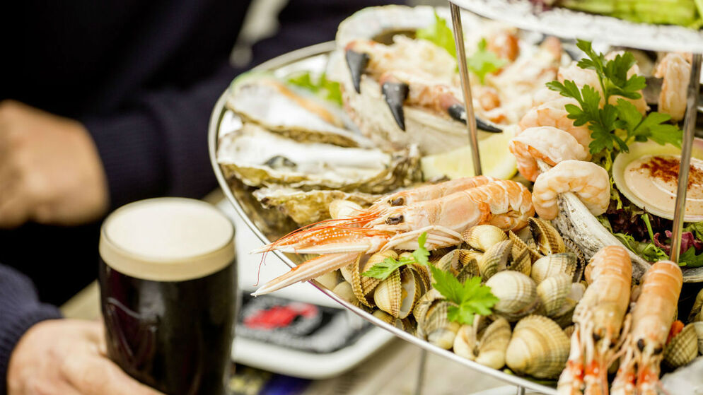 Meeresfrüchtesteller mit Austern, Garnelen, Krabbe und Muscheln, serviert mit Stout bei einem irischen kulinarischen Erlebnis.