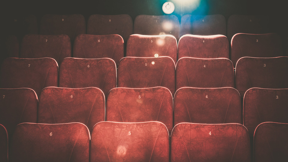 Sièges de cinéma rouges vides éclairés par un projecteur, utilisés pour promouvoir le reportage ' 12 Great Irish Movie Stars ' (12 grandes stars de cinéma irlandaises).